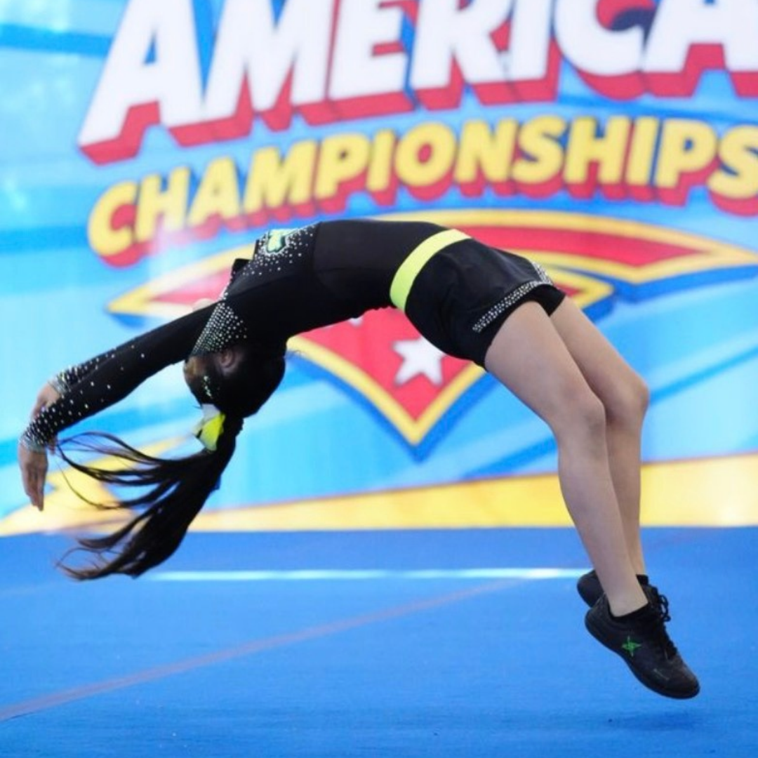 Cheer athlete performing a back handspring at a cheer championship